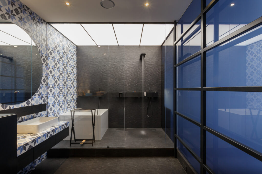 Projetos de arquitetura e design de interiores que valorizam imóveis | Foto de um quarto com cama de casal azul marinho e um dossel em ferragem preta