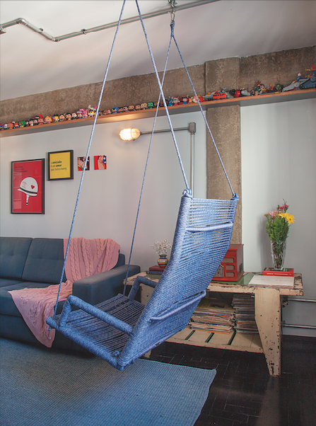 Cadeira de balanço em tecido de tons azuis decoram a sala de estar