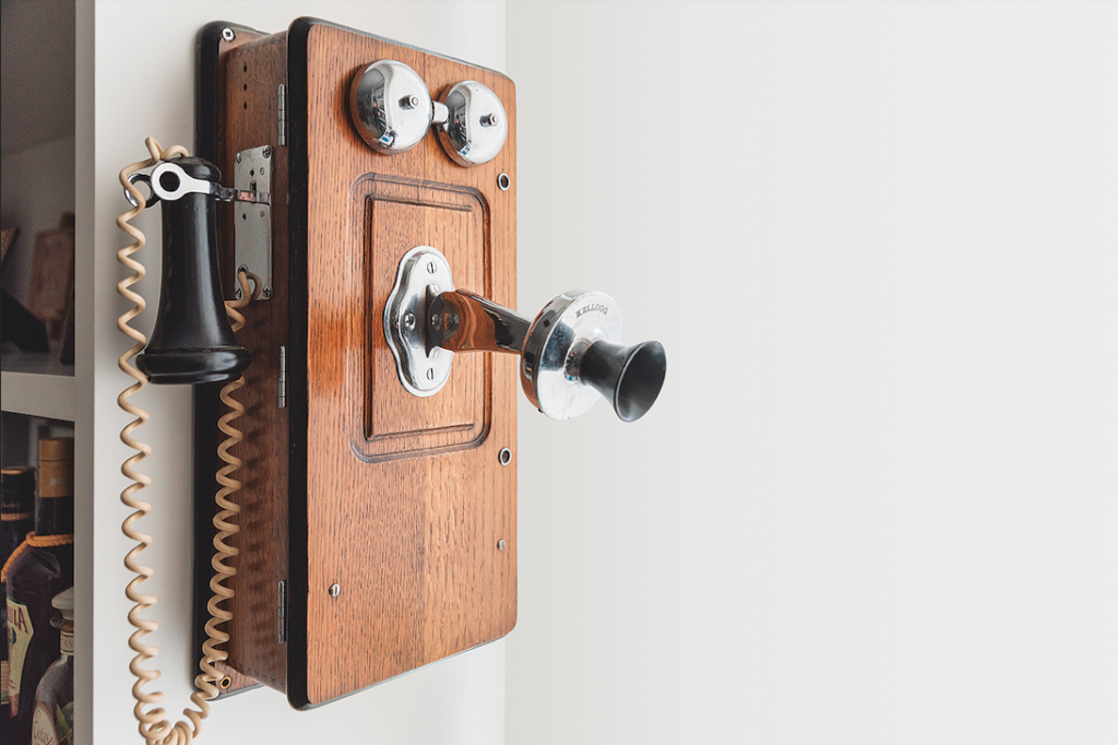 Telefone antigo de parede em madeira e metal