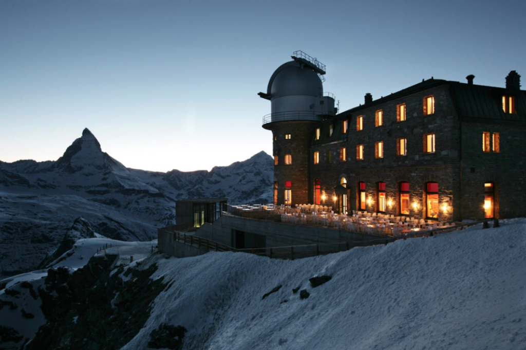 Kulm Hotel | Foto do hotel visto por fora com a paisagem em neve ao fundo